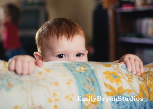 Cute baby peeking over a pillow